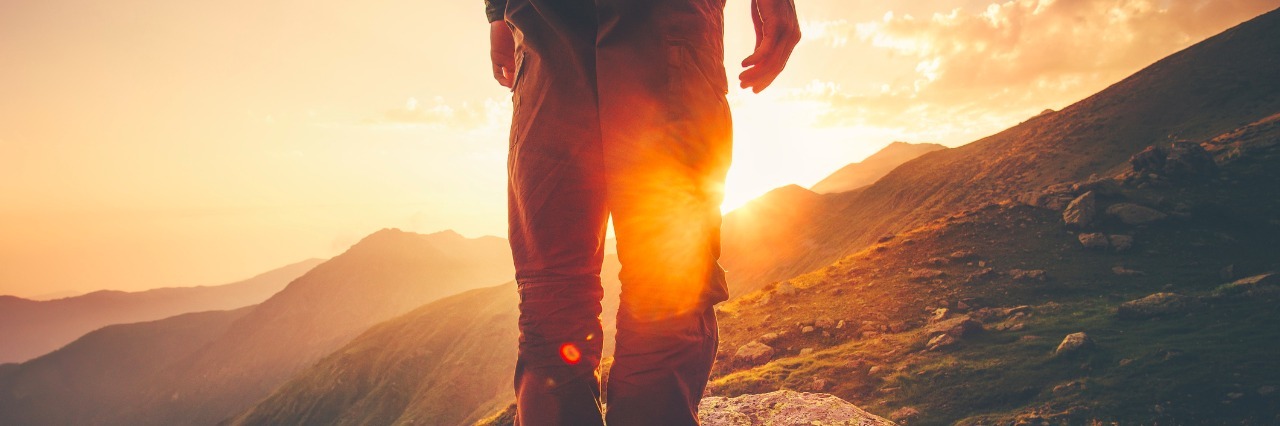 How to Manage Anxiety During a Period of Waiting young man standing outdoors looking at mountains