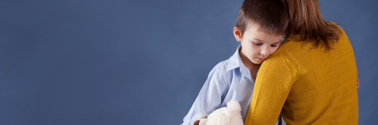 The System Is Broken for Foster Kids With Disabilities Sad little boy being hugged by his foster mother.