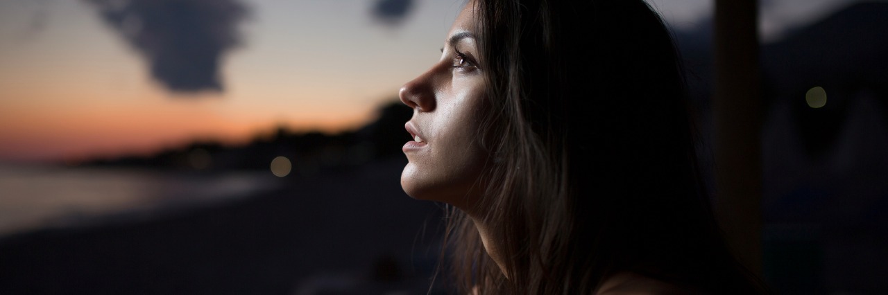 The Silver Linings of Chronic Illness Woman watching the ocean,sea horizon with a Moon on the sky.Eclipse of the Moon.Eclipse of the sun.Stargazing,watching stars on the beach under the moonlight