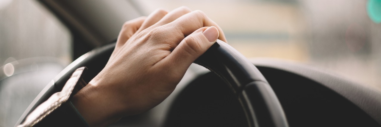 close up of woman's hand driving car