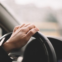 Close-up of a woman's hand driving a car