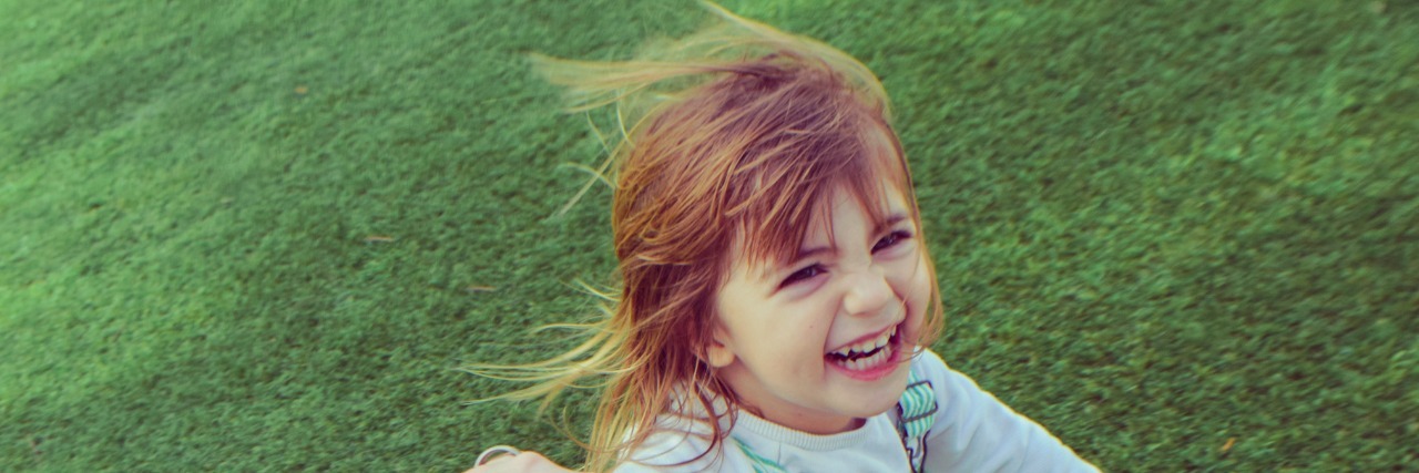 To My Sweet Child, From Your Mom With Mental Illness Silly little girl holding a parents hand barefoot in the grass, laughing