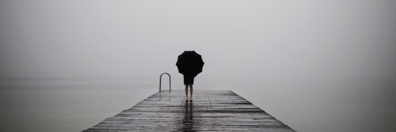 Woman with a umbrella on a dock