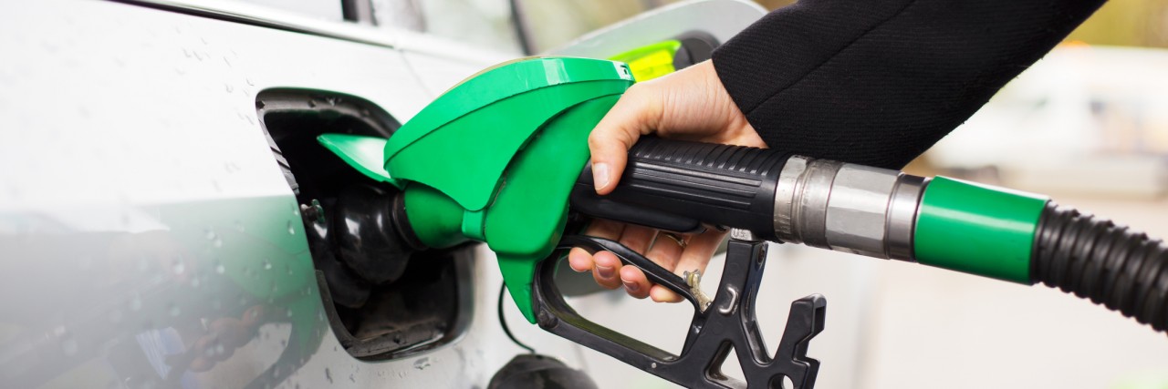 Daily Tasks Feel Impossible When You Live With Bipolar Disorder Close-up photo of hand holding fuel pump and refilling car at petrol station