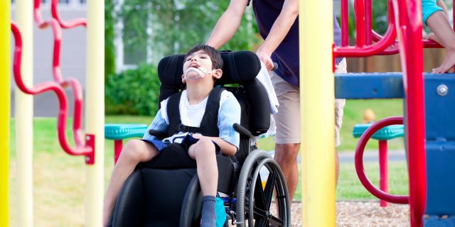 How to Make Playgrounds More Inclusive for Children With Disabilities Boy in wheelchair at the playground.