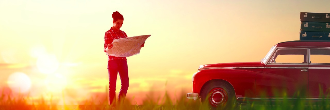 Going Outside My Comfort Zone: Road Tripping With Crohn's Disease woman standing next to car holding a map