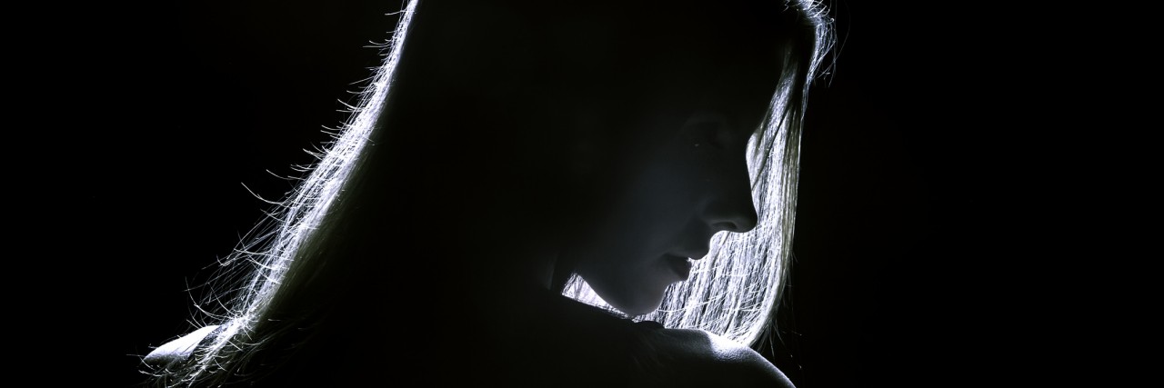 Experiencing Depression and Suicidal Ideation in High School sad woman profile silhouette in dark