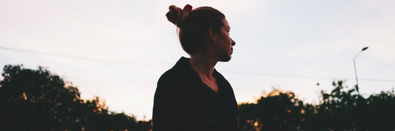 Getting an Asperger's Diagnosis as a 19-Year-Old Woman in front of trees, looking to the side