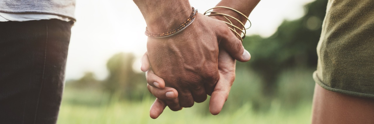 Dealing With Fibromyalgia in a Marriage couple holding hands and walking through a field