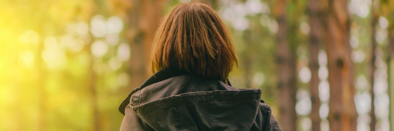 When Scoliosis Makes Some Activities Harder for Me Woman wearing jacket, walking near trees in park in daytime