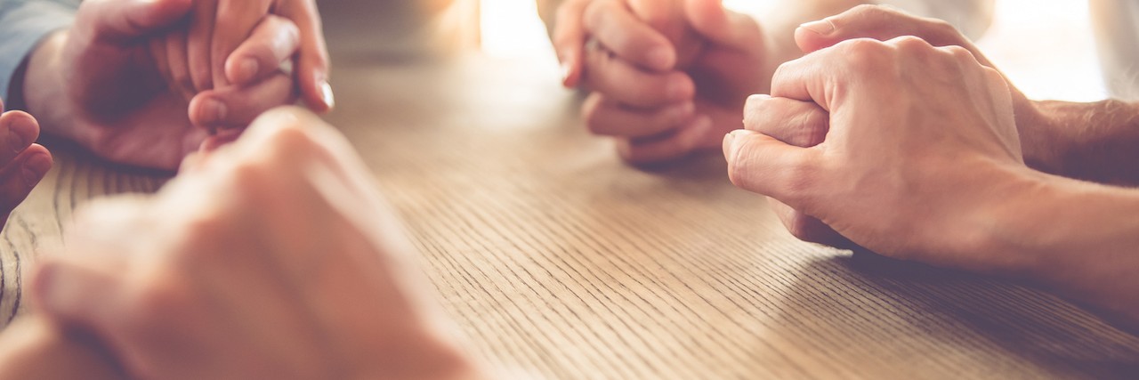 Thank You to Those Who Helped During My Depression A group of people sitting around a table holding hands