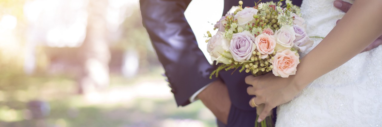 a bride and groom standing outside