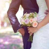 a bride and groom standing outside