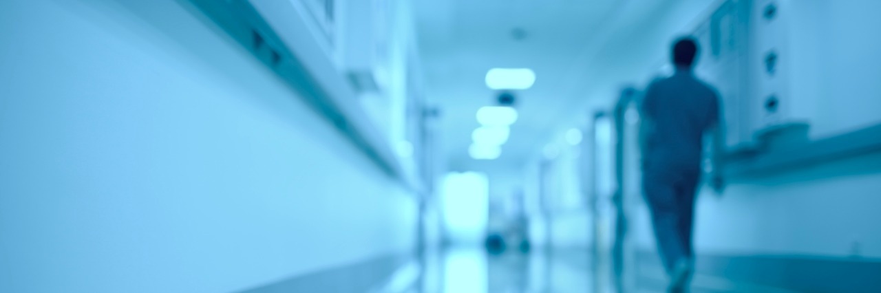 Blurred medical background. Moving human figure in the hospital corridor.