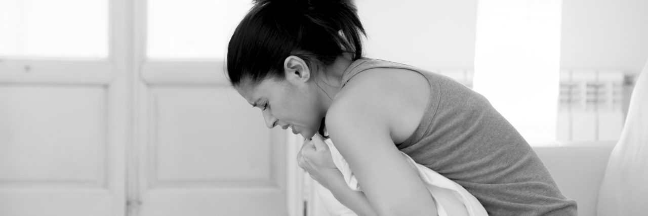 What Going to the Hospital With Dercum's Disease Is Like woman in pain on the couch