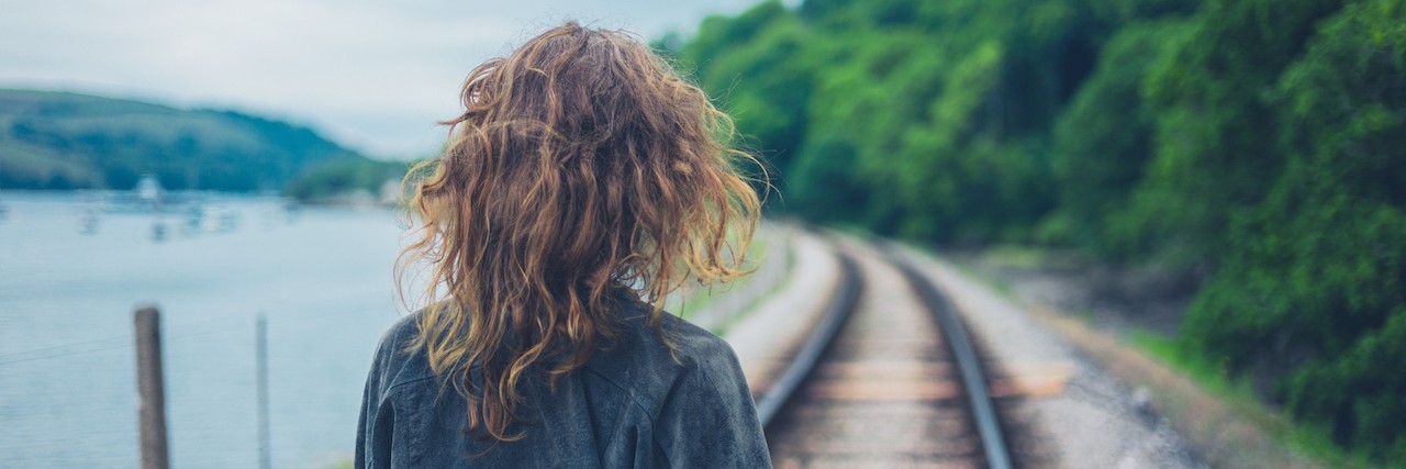 What It's Like to Be 'Almost Recovered' From Depression A young woman walking on the railroad tracks