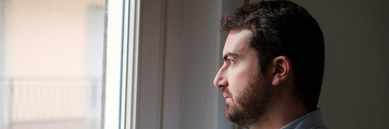 Portrait of sad man looking out of the window