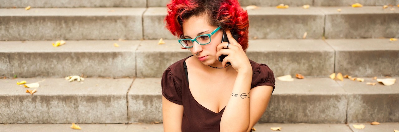 Girl sitting on stairs on her phone