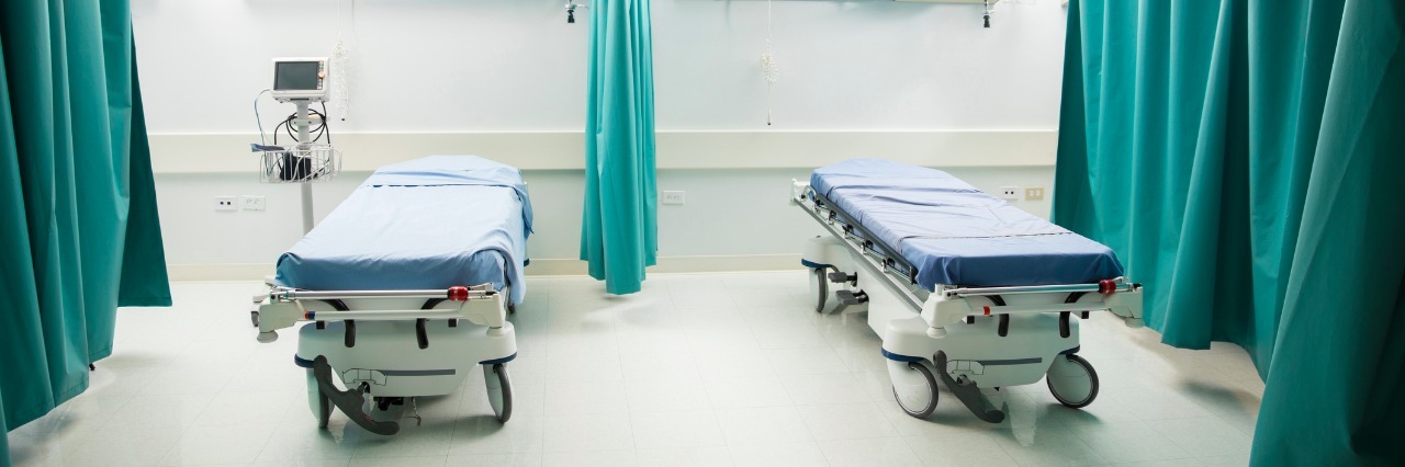 Wide view of a couple of empty beds in an emergency room at a hospital
