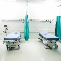 Wide view of a couple of empty beds in an emergency room at a hospital