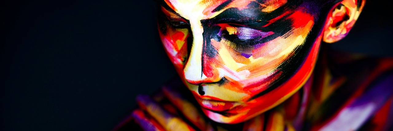 What I Feel Like Right Now With Ehlers-Danlos Syndrome woman's face and arms covered in multicolored paint