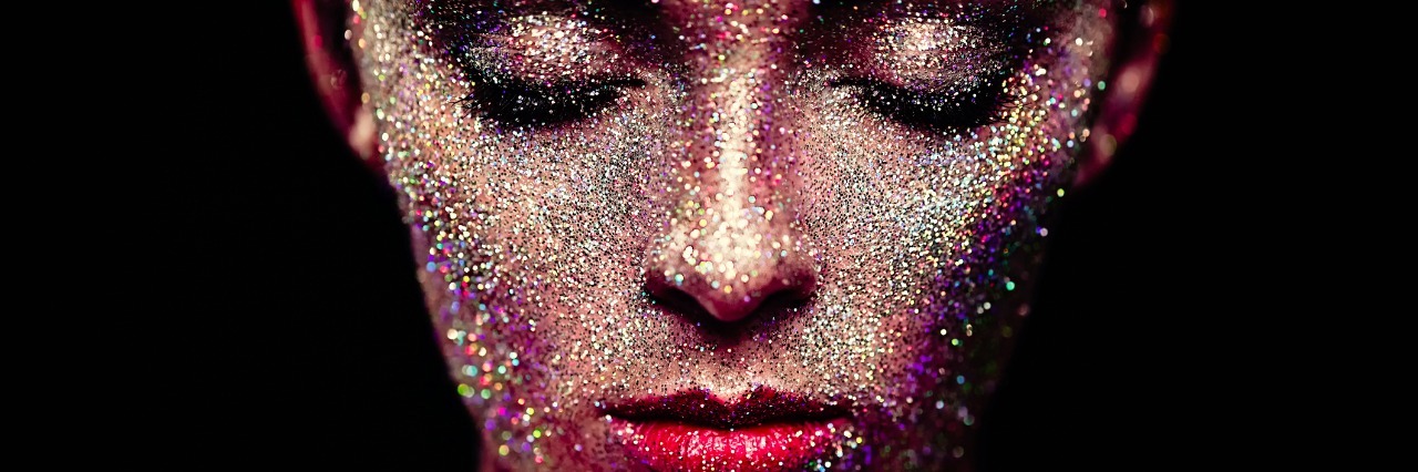 What Others Don't See in People with Controlled Epilepsy Portrait of woman with sparkles on her face. Girl with art make up in color light. Fashion model with colorful make-up