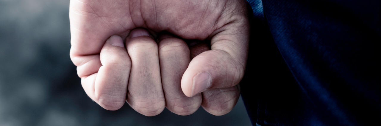 How to Respond to People Who Invalidate Your Mental Illness young man clenching his fist