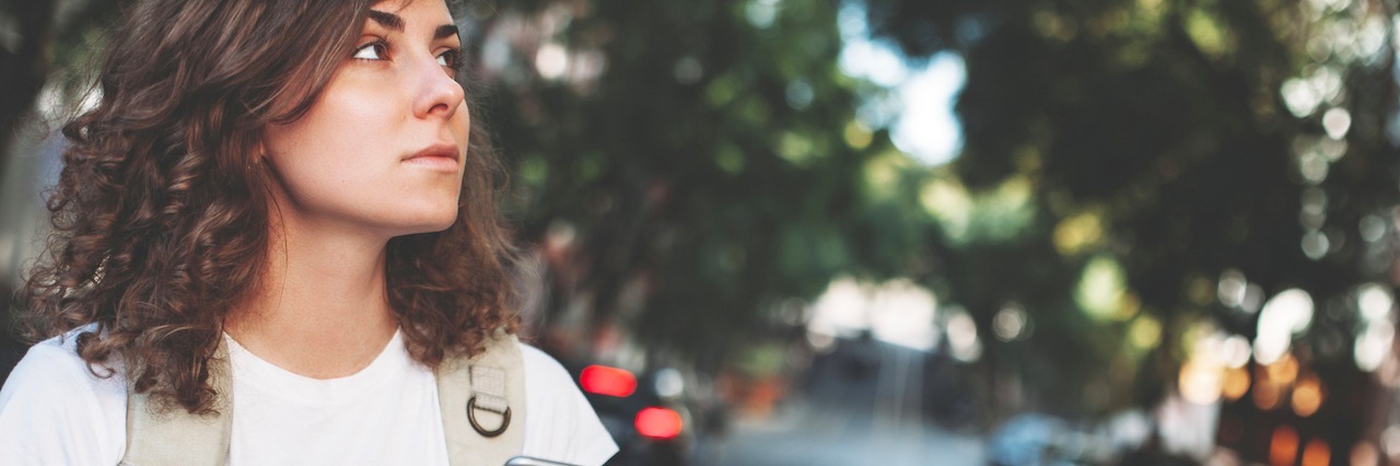 How Social Anxiety Affects People in Everyday Situations A woman with her phone standing in the street