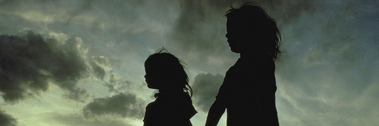 Silhouette of two girls holding hands