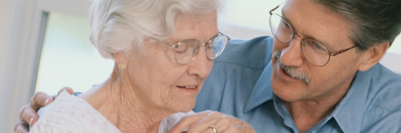 Caring for Other People With Disabilities When You're Disabled Male caregiver helping client with medication.