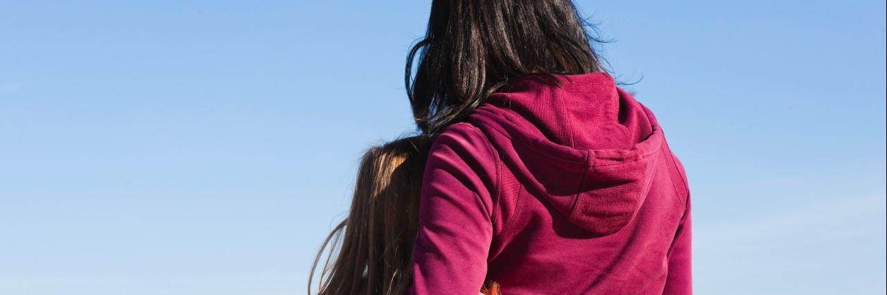 Please Don’t Call My Child’s Meltdown a ‘Tantrum’ Mother and daughter standing together with mother's arm around daughter