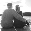 Couple sitting on dock in lake