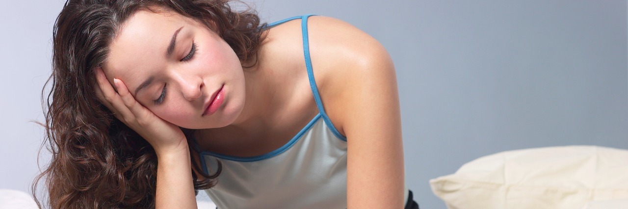 7 of the Hardest Parts of Chronic Illness girl sitting on edge of bed tired