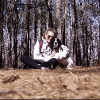 girl sitting in woods with dog