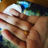 picture of a hand with a yellow pill int he middle