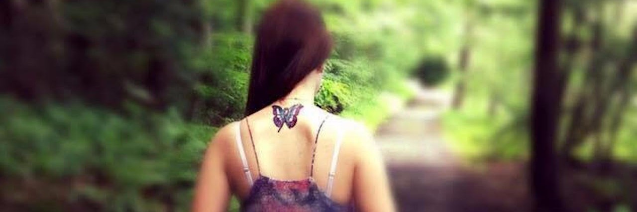 Chronic Pain: Starting the 'I Had a Good Day' Project woman with a butterfly tattoo walking barefoot on a path through the woods