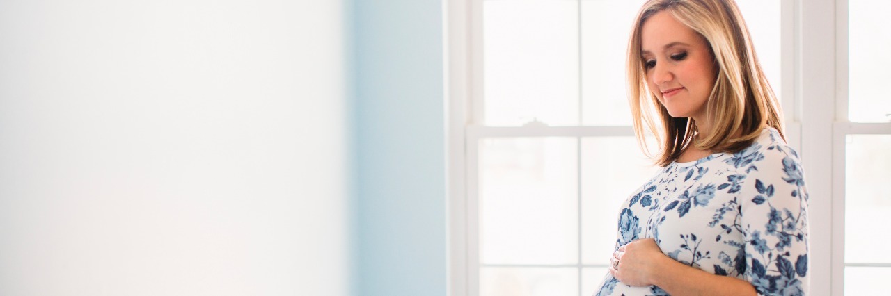 How I Decided Not to Breastfeed My Son as a Mom With Crohn's Disease pregnant woman standing by window