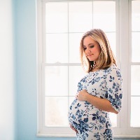 pregnant woman standing by window