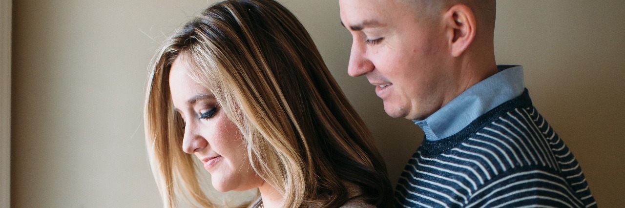 How Crohn's Disease Prepares a Woman for Pregnancy man and woman standing next to each other and holding woman's pregnant belly