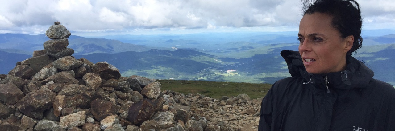 Living Life Within My Limits and Without Boundaries woman standing at top of mountain in front of pile of rocks