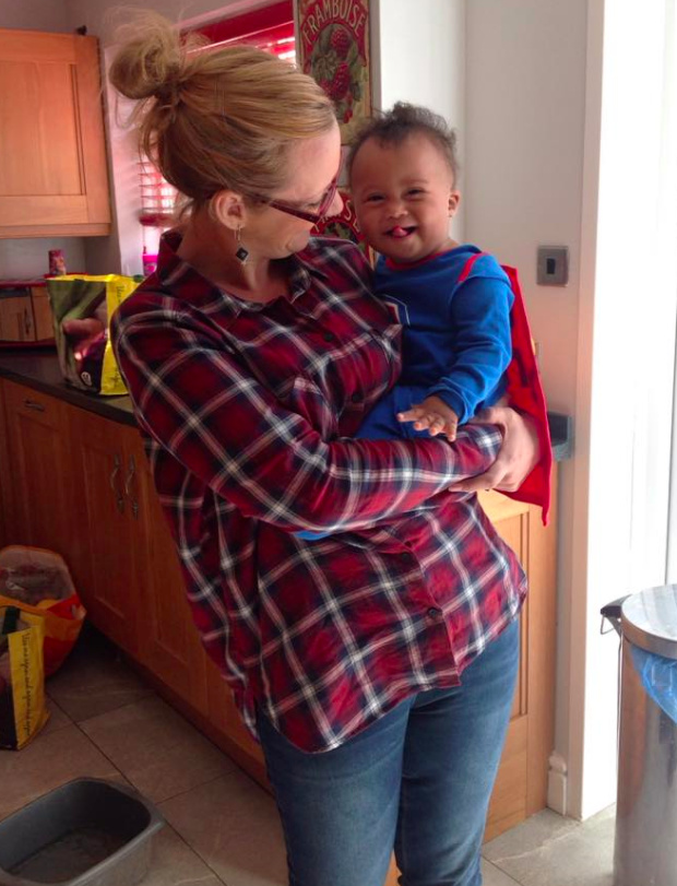 Mom holding her son, with face turned toward him, smiling