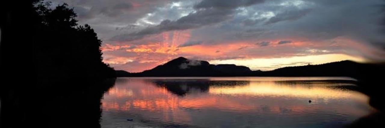 Joanne Zeis Advocates and Raises Awareness for Behcet's Disease sunset over a lake
