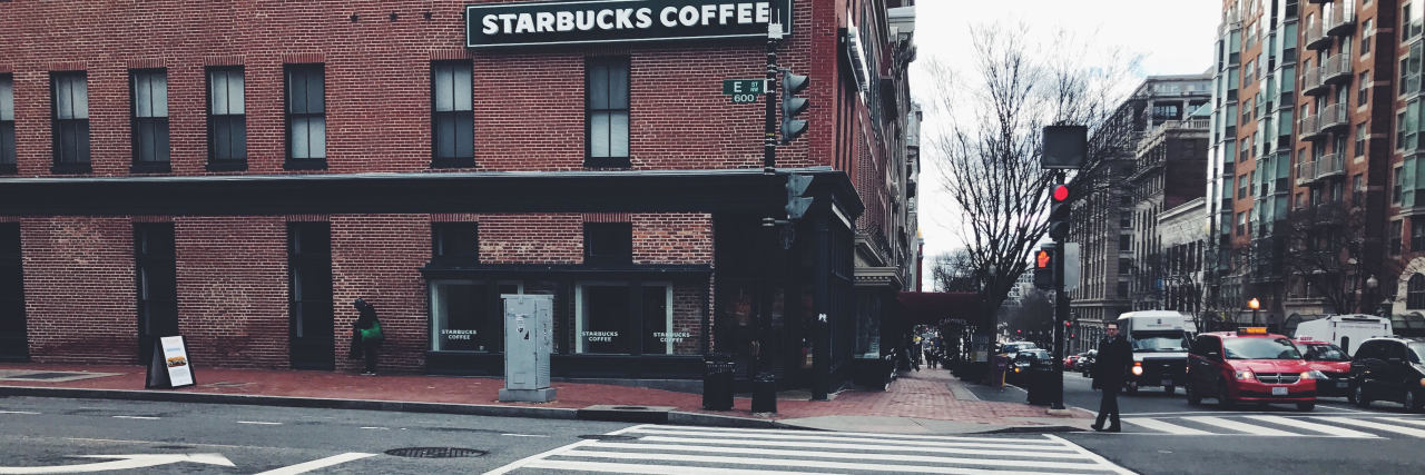 Travel Tips for People With IBD, Crohn's, Ulcerative Colitis photo of crosswalk in front of brick building and starbucks coffee sign