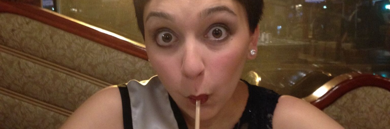 Getting Diagnosed With Ulcerative Colitis and Feeling Like a Princess young woman wearing a dress, tiara, and sash at a diner drinking a milkshake