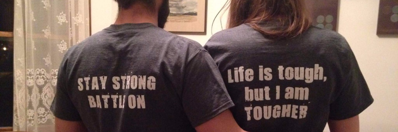 Fibrosing Mediastinitis: Being Married With a Rare Disease husband and wife wearing t-shirts that say 'stay strong, battle on' and 'life is tough, but I am tougher'