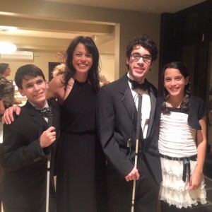 Kristin with her sons and daughter, dressed in formal attire at a party.