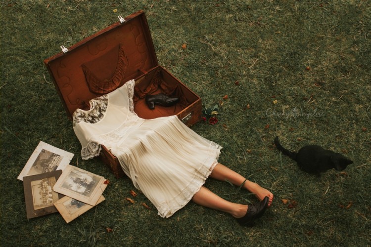 photo of a dress in a suitcase with legs sticking out