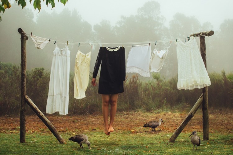 Woman without a head wearing a dress hanging on a clothes line.