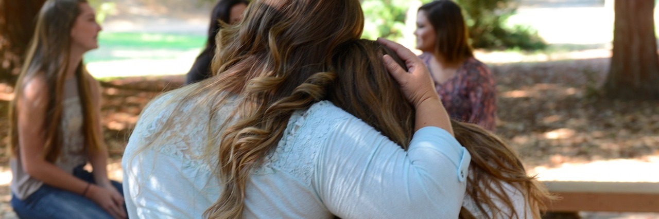 Back view of two girls hugging each other