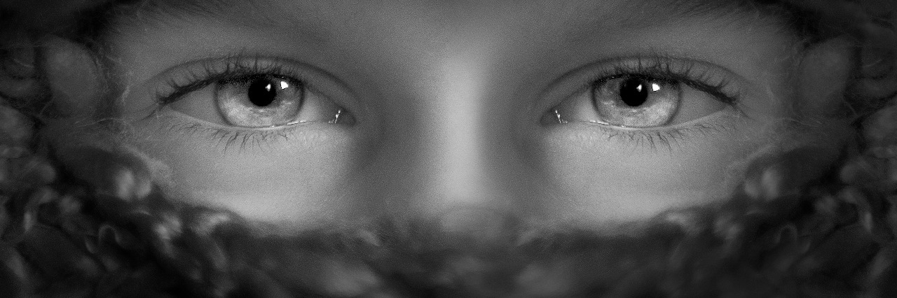 BLACK AND WHITE IMAGE OF EYES AND COVERED FACE